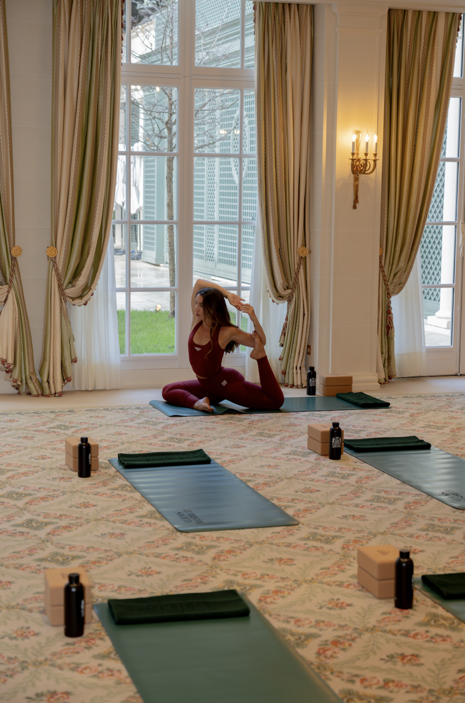 Séance de Pilates avec Laure Dary au salon Versailles du Bristol Paris, avec vue sur le jardin de l'établissement.