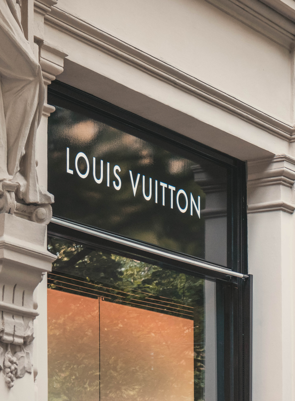 Ein Modell sieht bei Logos von Louis Vuitton auf eine Wand an der Louis  Vuitton Bereich innerhalb des Frankreich Pavillon auf der Expo in Shanghai,  China erwartet Stockfotografie - Alamy
